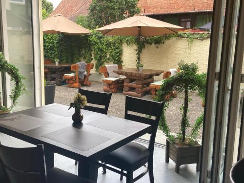 a patio with a table and chairs and an umbrella at Harzhotel Warnstedter Krug in Thale