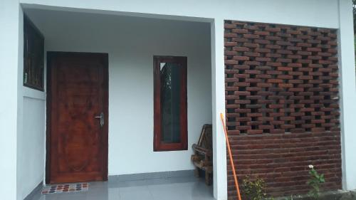 a house with a brick wall and a door at MANDALIKA Homestay in Kuta Lombok