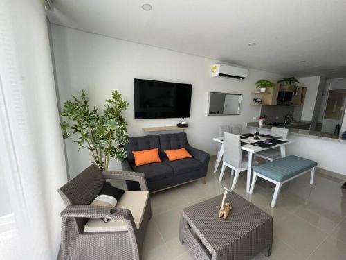 a living room with a couch and a table with chairs at Reserva del Mar, Hermoso lugar de Descanso en Santa Marta in Gaira
