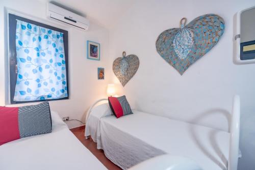 a bedroom with two beds with hearts on the wall at Villa Monica in Costa Rei