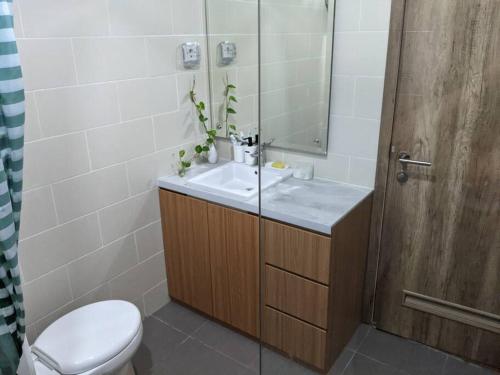 a bathroom with a sink and a toilet and a mirror at Apt Pejaten Park 1 BR Sage Smart TV, Netflix, Prime, Youtube in Jakarta