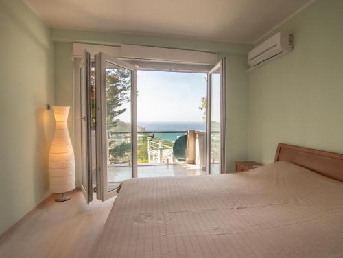 a bedroom with a bed and a view of the ocean at Mum's Apartment in Petrovac na Moru