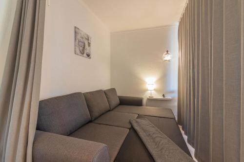 a living room with a couch and a curtain at Vilamoura Cosy 2 with Pool by Homing in Vilamoura