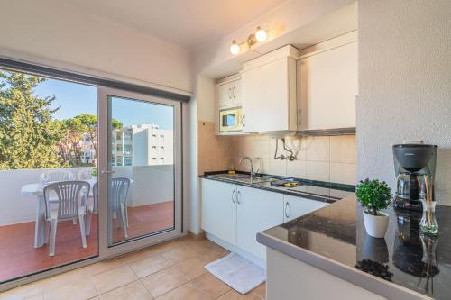 a kitchen with a counter and a table with chairs at Vilamoura Cosy 2 with Pool by Homing in Vilamoura