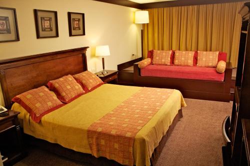 a hotel room with a bed and a couch at Amérian Hotel Casino Gala in Resistencia