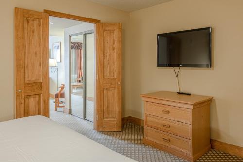 a bedroom with a bed and a dresser with a television at Grand Lodge Condo in the Heart of Mt Crested Butte condo in Crested Butte