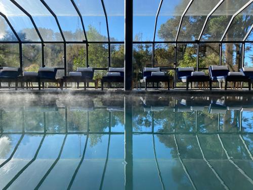 a swimming pool with chairs and water in a building at Ort Hotel in Campos do Jordão