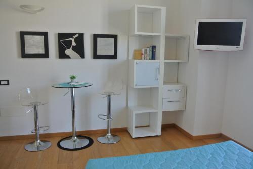 a living room with a white book shelf and a tv at Marina Di Castello in Cagliari