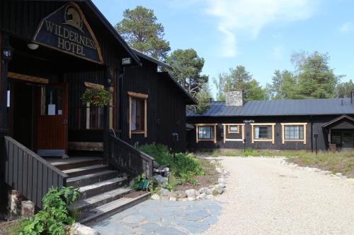 a black building with a staircase outside of it at Wilderness Hotel Nellim & Igloos in Nellimö