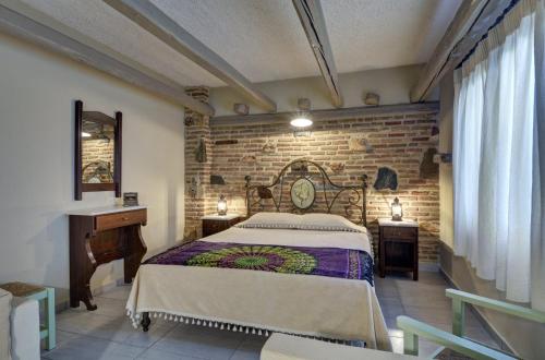 - une chambre avec un lit et un mur en briques dans l'établissement Likoudis Villas Suites ,on the Kioni,Ionian Islands Ithaca,, à Kiónion