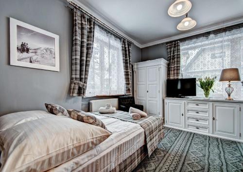 1 dormitorio con 1 cama y TV en una habitación en Willa Camaro, en Zakopane