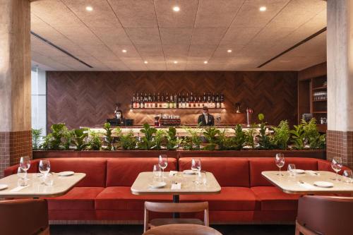 a restaurant with a red couch and a bar at Costanero Hotel Montevideo - MGallery Collection in Montevideo