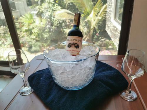 a bottle of wine in a bucket of ice with two glasses at La Casa De Mi Sub in Puerto Baquerizo Moreno