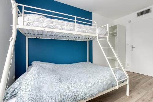 1 dormitorio con litera y pared azul en Le Moulin Haut, en Magny-le-Hongre