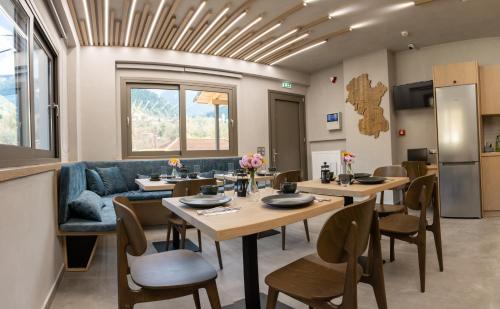 ein Esszimmer mit Tischen und einem blauen Sofa in der Unterkunft Evora Luxury Suites in Méga Khoríon