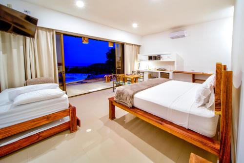 a bedroom with a bed and a large window at Akua Suites Ocean View in Tarcoles