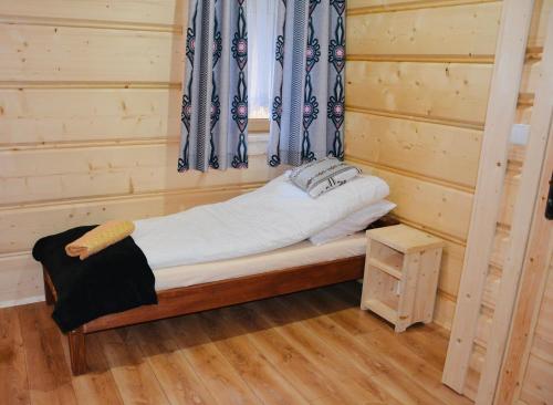 a small bed in a room with a window at Agroturystyka na starej drodze in Witów