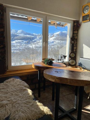 a room with two tables and a large window at Konak Umoljani in Umoljani