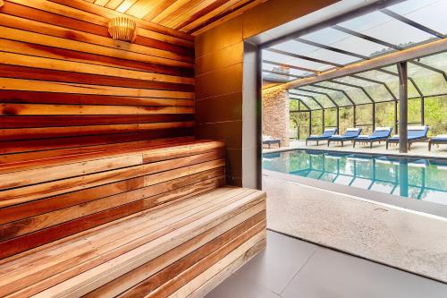 a sauna with a wooden wall and a swimming pool at Ort Hotel in Campos do Jordão