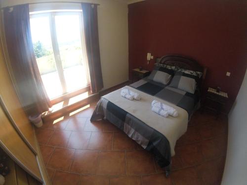een slaapkamer met een bed met twee handdoeken erop bij Villa Casa Brandao in Póvoa de Varzim