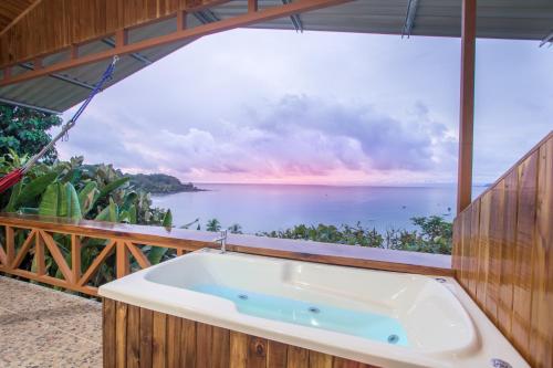 a bath tub with a view of the ocean at Las Cotingas Ocean View in Drake