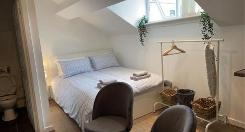 a bedroom with a bed with a chair and a window at CityNights Studios with Free Parking in Liverpool