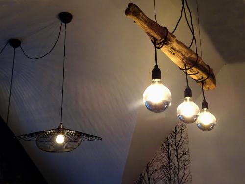 a group of lights hanging from a ceiling at 1B, Stuga m havsutsikt & 50m till strand in Byxelkrok
