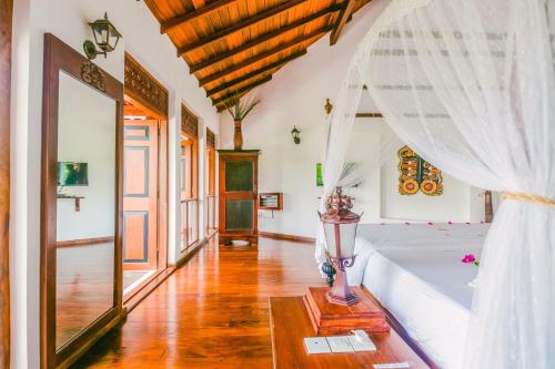 a bedroom with a bed with a white curtain at Waterland in Negombo