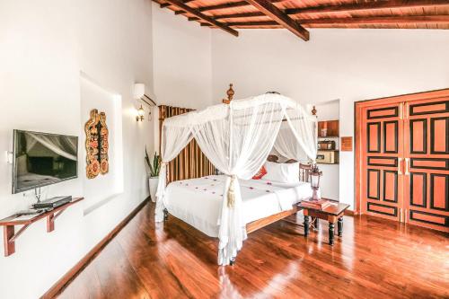 a bedroom with a white bed with a canopy at Waterland in Negombo