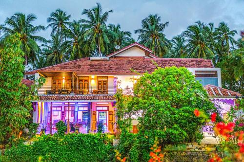 a house with palm trees in the background at Waterland in Negombo