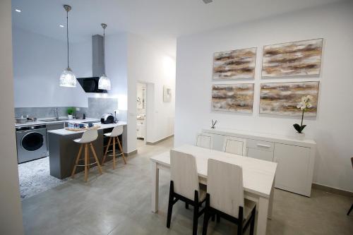 een witte keuken met een tafel en stoelen. bij Casa del Telegrafo in Utrera