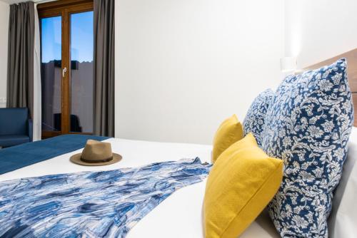 a bed with blue and white pillows and a hat on it at LIRESCA in Lires