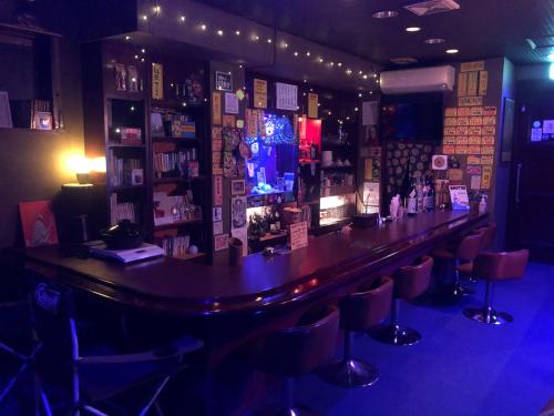 a bar in a bar with stools in a room at 尾道ゲストハウス シータ村 in Onomichi