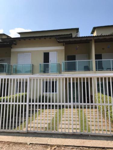 a white fence in front of a house at Juquehy Casa Confort para Famílias em condomínio in Juquei