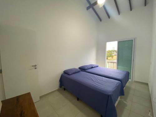 a small bedroom with a bed and a window at Juquehy Casa Confort para Famílias em condomínio in Juquei