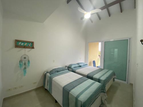 two beds in a hospital room with a window at Juquehy Casa Confort para Famílias em condomínio in Juquei