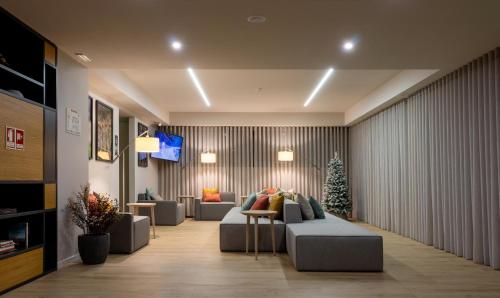 a living room with a couch and a christmas tree at Meu Hotel Porto Gandra in Paredes