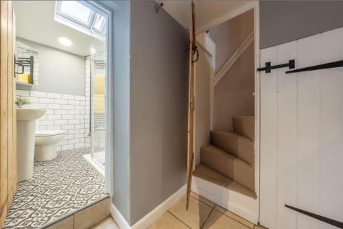 a bathroom with a staircase leading to a bathroom with a toilet at Wishing Well Cottage in North Creake