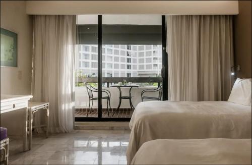 ein Hotelzimmer mit einem Bett und einem Balkon in der Unterkunft Beach Front Place in Cancún