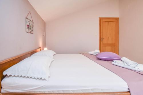 ein Schlafzimmer mit einem weißen Bett mit zwei Handtüchern darauf in der Unterkunft Apartments Svarog in Biograd na Moru