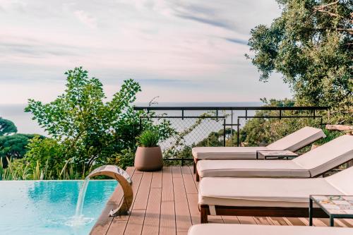 a pool with chaise lounge chairs and a swimming pool at L'Olearia Luxury Country Villa in Amalfi Coast in Maiori