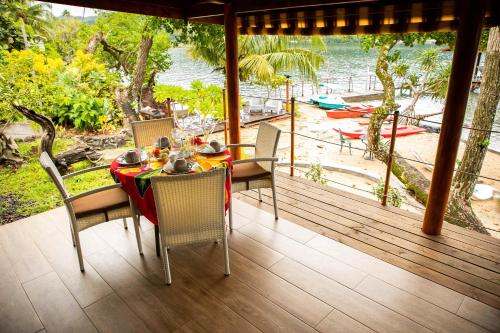 a table and chairs on a deck with a view of the ocean at Raiatea sur Mer in Opoa