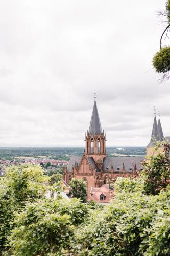 an old building with towers on a hill with trees at Weinzuhause Hotel-Restaurant-Vinothek in Mommenheim