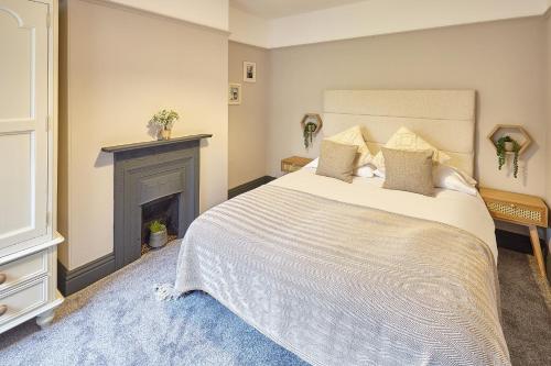 a bedroom with a large bed and a fireplace at Queens Road 2 Bed apartments Central Richmond in Richmond