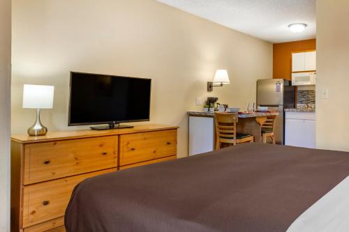 a bedroom with a bed and a flat screen tv at Suburban Studios Albuquerque Uptown in Albuquerque