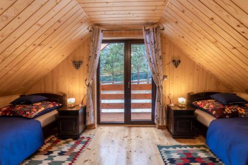 a room with two beds and a window in a cabin at Domki na Mosornym in Zawoja