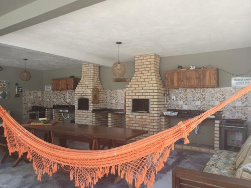 a living room with an orange hammock in front of a fireplace at Vila Alegria in Bombinhas