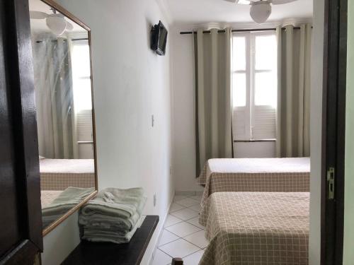 a small room with two beds and a mirror at Pousada Suítes Do Pelô in Salvador