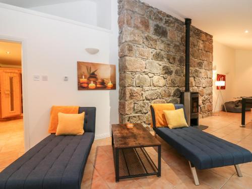 una sala de estar con 2 sofás y una pared de ladrillo en Boat House, en Aberdeen