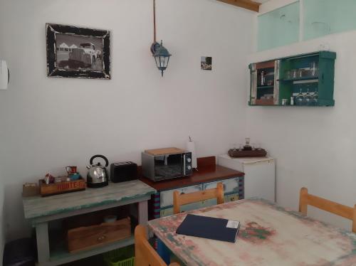 a small kitchen with a table and a microwave at Over Karoo Inn in Barrydale
